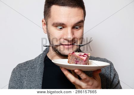 Closeup Portrait Young Cute Caucasian Man Smile, Hold Fork In His Teeth And White Round Plate With P