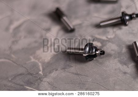 Scattered Set Of Steel Router Bit For Milling Cutter On Old Broken Worn Gray Concrete Floor With Cop