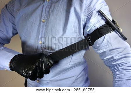 Person In Black Medical Gloves Applies The Tourniquet To His Hand To Prevent Bleeding During The Fir