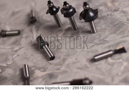 Scattered Set Of Steel Router Bit For Milling Cutter And Row Of Three Bits On Old Broken Worn Gray C