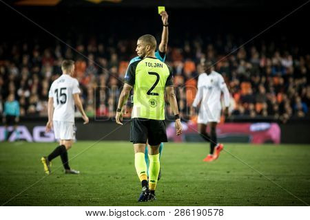 VALENCIA, SPAIN - FEBRUARY 21: Referee shows yellow card to Toljan during UEFA Europa League match between Valencia CF and Celtic FC at Mestalla Stadium on February 21, 2019 in Valencia, Spain