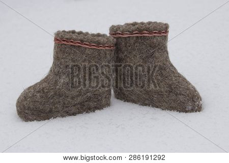 A Pair Of Russian Felt Boots Standing On White Snow In Winter Close-up
