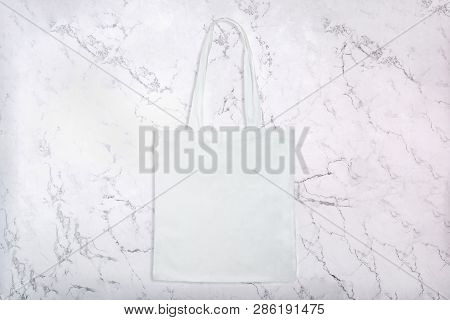 Reusable White Fabric Bag On White Natural Marble Texture As Background. Top View