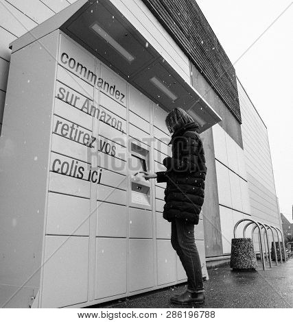Strasbourg, France - Feb 8 2018: Young Woman Using Amazon Locker The Self-service Parcel Delivery Se