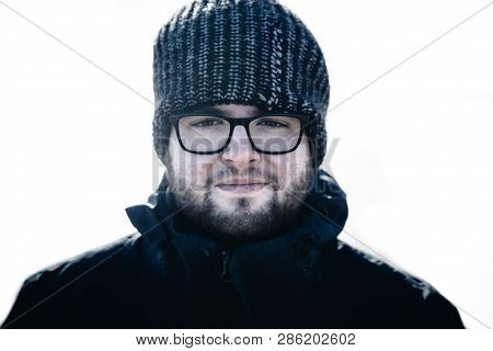 A Male Portrait Of A Handsome And Rugged Young Man Wearing Glasses And A Wooly Hat In A Cold Environ