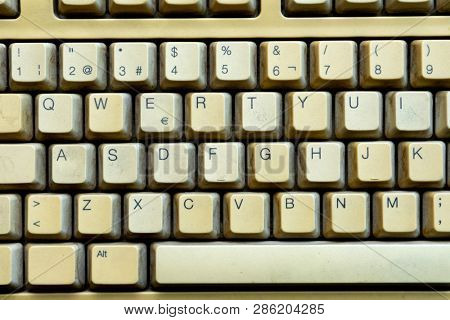Old keyboard of a computer cloes up, with letters and numbers