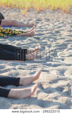 Detail Of People Performing Yoga Nidra On Sand
