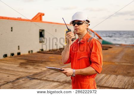 Deck Officer On Deck Of Offshore Vessel Holds Vhf Walkie-talkie Radio