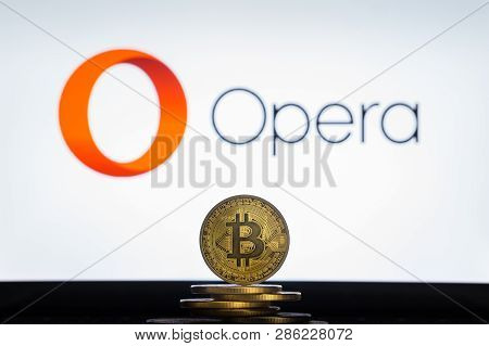 Bitcoin On A Stack Of Coins With Opera Logo On A Laptop Screen. Cryptocurrency And Blockchain Adopti