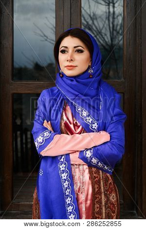 Beautiful Azeri Woman In Traditional Azerbaijani Dress Standing At The Wooden Window