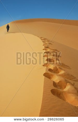 Nomad camminando su una duna di sabbia del Sahara