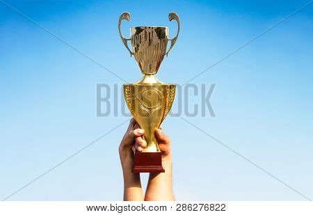 Winner, Win, Champions Cup, Prize. Winners Holding Champion Golden Trophies. Hand Of The Person With