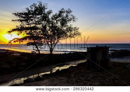 Beautiful Golden Sunset Sandy Beach And Tropical Trees At Taman Damai Or Surrender Point Landmark Ww