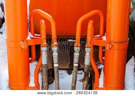 Orange Tubes And Hoses System Of Hydraulic Drives On A Construction Machine Outdoor In Snow, Close U