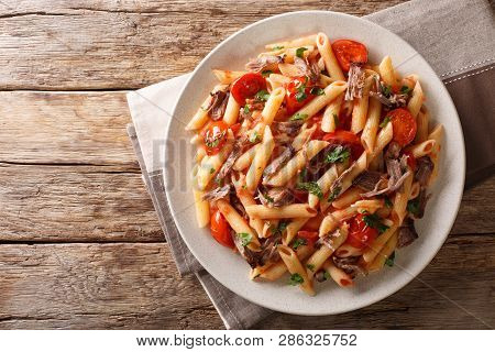 Serving Penne Pasta With Pulled Pork, Cheese, Tomato Sauce And Herbs Close-up On A Plate. Horizontal