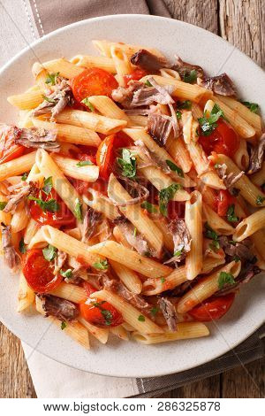 Italian Pasta With Baked Shredded Pork, Cheese, Tomato Sauce And Herbs Close-up On A Plate. Vertical