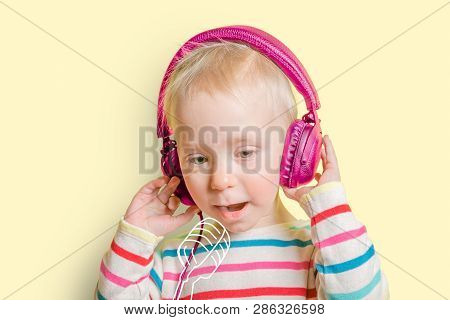 Young Toddler Girl Listening To Headphones And Singing To Imaginery Mic. Talent Show Concept