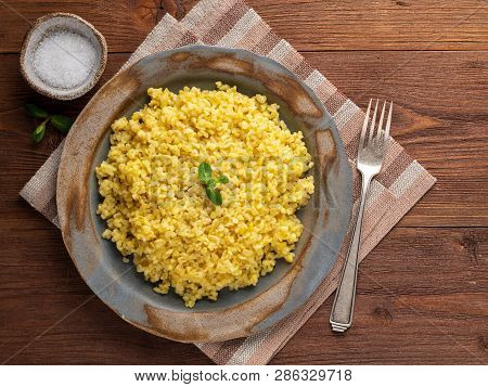 Bulgur Wheat. Boiled Bulghur Cereal In Plate On Brown Wooden Table. Healthy Vegetarian Food, Top Vie
