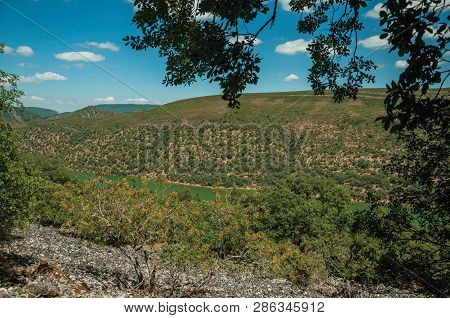 Tagus River Running Through A Valley With Hills Covered By Trees, In A Sunny Day At The Monfrague Na