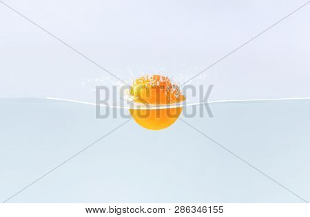 Detox. Fresh Orangefruit Falling In Water With Splash, Blue Background, Free Space