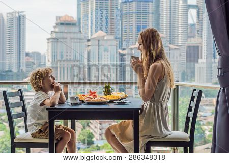 Happy Family Having Breakfast On The Balcony. Breakfast Table With Coffee Fruit And Bread Croisant O