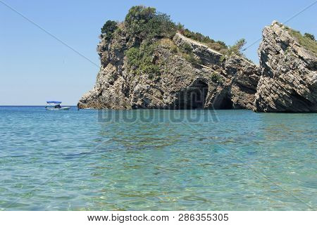 Rocks And Boat On Island Of St. Nicholas In Budva, Montenegro. Paradise Beach On Island In Sea