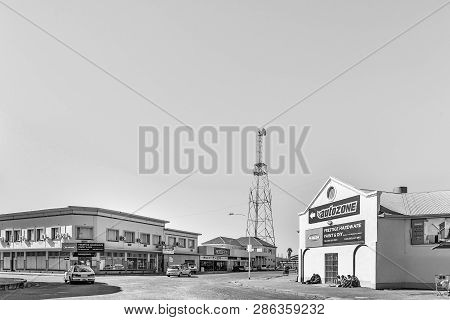De Aar, South Africa, August 6, 2018: A Street Scene, With Businesses, Vehicles And People, In De Aa