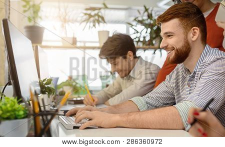 Cheerful System Administrator Working On Computer In Office, Upgrading Software System For Team, Pan