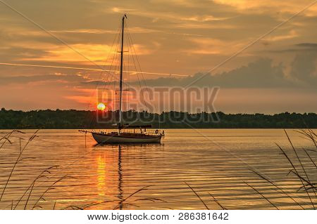 Long Day Of Sailing On The River Ends At Anchor With The Sun Setting In The West
