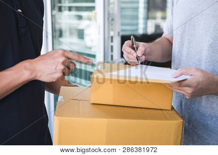 Delivery Mail Man Giving Parcel Box To Recipient, Young Man Signing Receipt Of Delivery Package From
