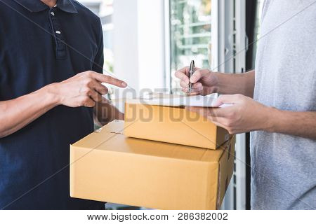 Delivery Mail Man Giving Parcel Box To Recipient And Signature Form, Young Owner Signing Receipt Of 