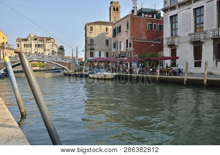 Venice, Italy - August 10, 2014: People Eating In A Restaurant Next To Guglie Bridge,  That Spans Th