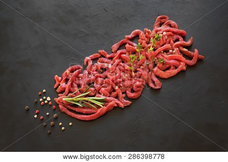 Flat-lay Of Fresh Raw Beef Meat On Black Table. Raw Veal Pieces Background. Beef Stroganoff.