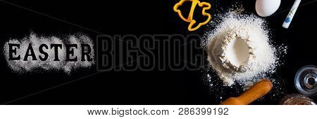 Handrful Of Sieved Flour With Egg Shape Hole In The Center And Utensils For Baking And Ingredients A