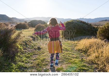 Little girl running through the Spanish landscape, Rambla del Playazo, Cabo de Gata - Nijar Natural Park, Spain
