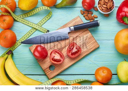 Fresh Vegetables, Fruit, Knife, Cutting Board And Centimeter On Wooden Background. Fitness Concept. 