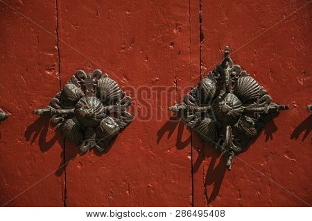 Close-up Of Finely Decorated Iron Studs Attached To Wooden Planks In An Old Door, In A Sunny Day At 