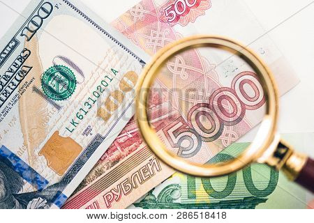 Five Thousand Russian Rubles  Under A Magnifying Glass On The Bacdrop Euro And Usa Dollar. Сoncept O