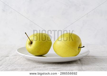 Imperfect Ugly Misshapen Fresh Golden Apples Rich In Vitamins Served On A Plate In A Low Angle View 