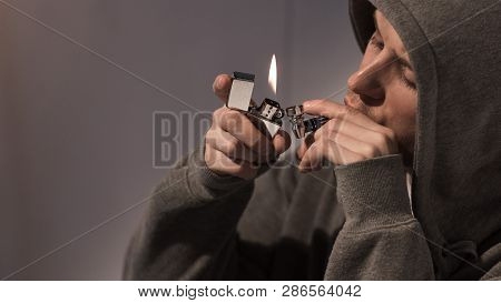 Selective Focus Of Addicted Man Lightening Smoking Pipe With Metallic Lighter