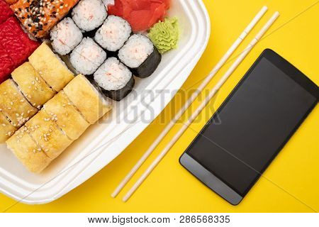 Top View On Sushi Set At Colored Background. Plate With Rolls, Ginger And Vasabi