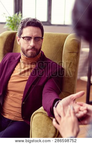 Nice Serious Smart Man Looking At His Hand