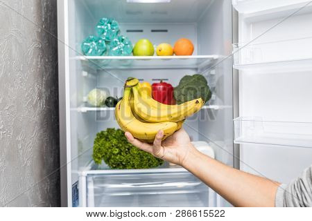 Hands Choose Banana From Full Friedge. Healthy Eating Concept