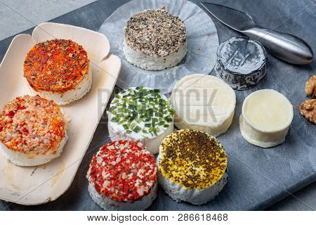 Assortment Of French Fresh White Soft Goat Cheeses With Different Tastes Topping Made With Herbs, Pa
