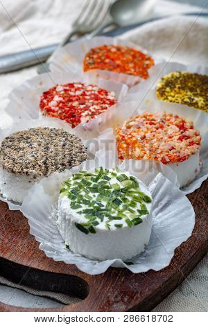 Assortment Of French Fresh White Soft Goat Cheeses With Different Tastes Topping Made With Herbs, Pa
