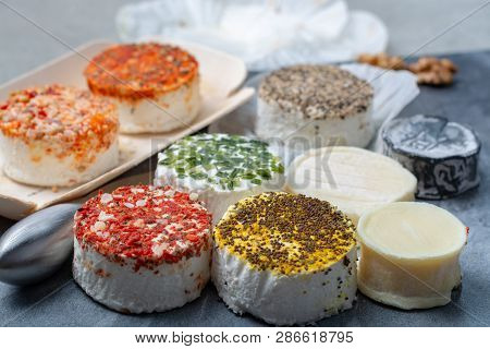 Assortment Of French Fresh White Soft Goat Cheeses With Different Tastes Topping Made With Herbs, Pa