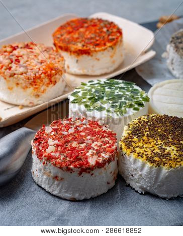 Assortment Of French Fresh White Soft Goat Cheeses With Different Tastes Topping Made With Herbs, Pa