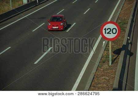 Cars Passing Through Multi Lane Highway And Speed Limit Signpost, On Sunset In Madrid. Capital Of Sp