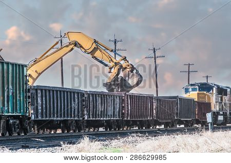 After A Section Of Track Was Rebuilt, An Excavator Is Used To Load The Old Rotten Ties Into Open Box