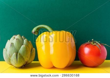 Ripe Organic Vegetables Artichoke Capsicum Tomato On Duotone Dark Green Yellow Background. Healthy P